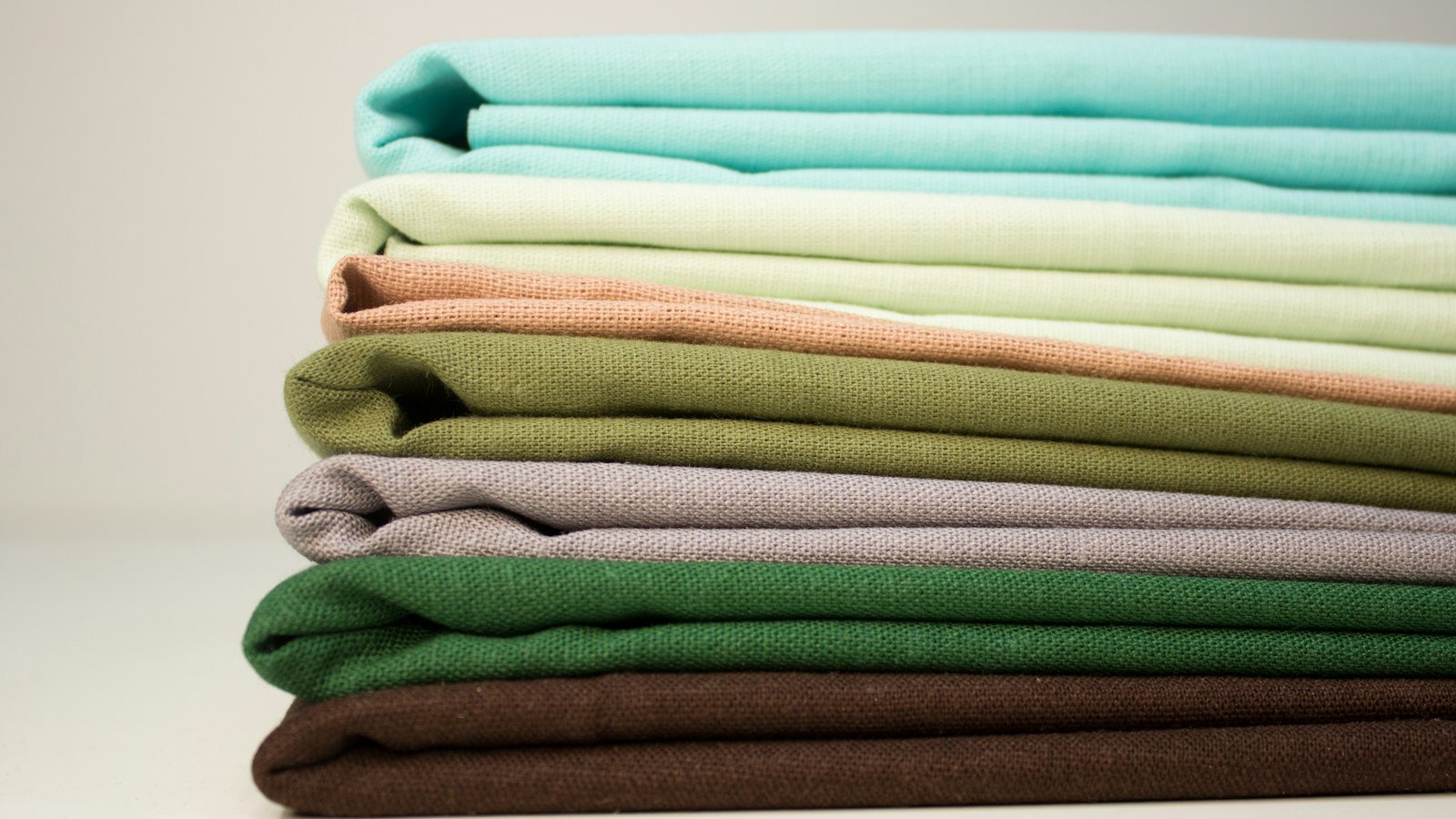 Stack of folded plain cotton cloths in soft colours